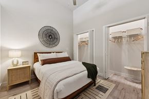 Austin apartment for rent - Bedroom with wooden bed and walk-in closets at Bridge at Windsor Park Apartments, Austin, TX