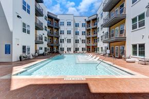 Austin apartment for rent - A swimming pool in the middle of a courtyard surrounded by buildings. at Park South Apartments, Texas