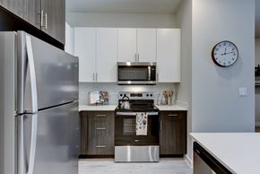 Austin apartment for rent - A modern kitchen with a stainless steel refrigerator and a microwave above the stove. at Bridge at Speyside Apartments, Texas, 78754