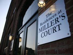 Baltimore apartment for rent - A sign that says "The Residences at Miller Court" is mounted on a brick wall.