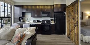 Baltimore apartment for rent - A kitchen with a black refrigerator and wooden floors.