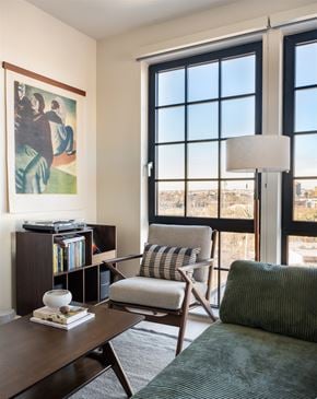 Baltimore apartment for rent - A living room with a chair, a table, a book and a painting.