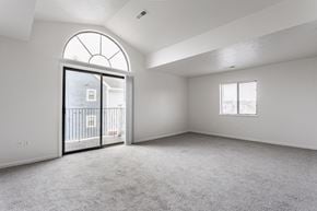 Merrillville apartment for rent - A spacious room with a large arched window and a sliding glass door leading to a balcony at Huntington Cove Apartments, Merrillville, IN, 46410