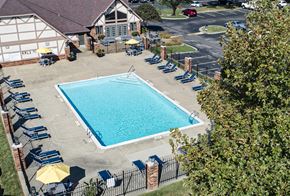 Evansville apartment for rent - a swimming pool in front of a house with chairs around it at The Timbers Apartments, Evansville, IN, 47715