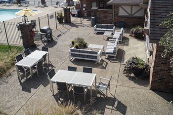 An outdoor patio with tables and chairs and a pool