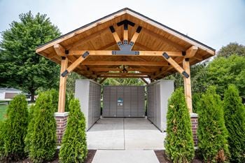 A wooden covered walkway leads to a garage