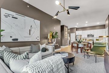 Henrico apartment for rent - A modern living room with a grey sofa and a large abstract painting on the wall.