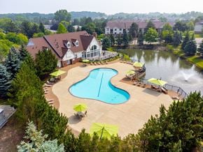 Novi apartment for rent - an aerial view of a resort style pool and spa with a house in the background at The Springs Apartment Homes, Novi