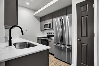 A kitchen with stainless steel appliances and a white counter top
