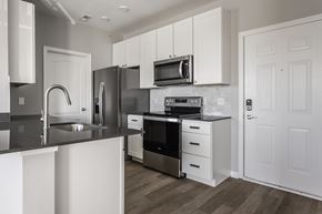 Carmel apartment for rent - a kitchen with white cabinets and stainless steel appliances at Alexandria of Carmel Apartments, Indiana