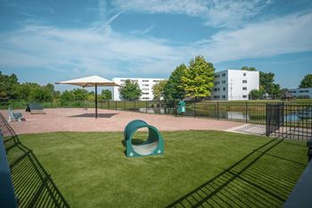 A playground with a green slide and a white building in the background