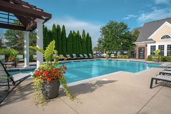 A pool surrounded by trees and a building