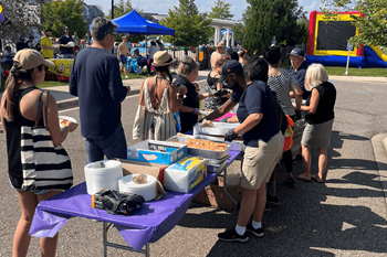 A group of people standing around a table with food on it