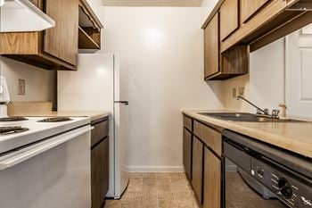 A kitchen with a white stove and a white refrigerator
