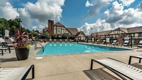 Miamisburg apartment for rent - A pool area with a large swimming pool, lounge chairs, and a potted plant