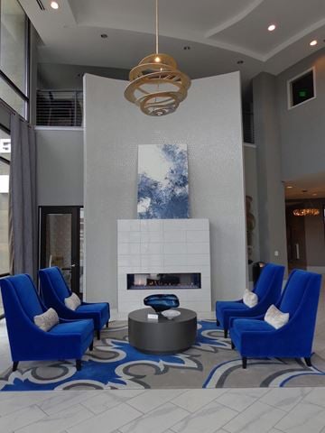Carmel apartment for rent - A modern living room with blue chairs and a fireplace.