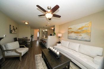 A living room with a white couch and a ceiling fan