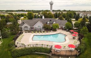 Grand Chute apartment for rent - A large building with a pool in front of it at Towne Lakes Apartments, Grand Chute