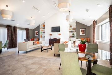 Indianapolis apartment for rent - A living room with a white couch and a red vase on a glass table.