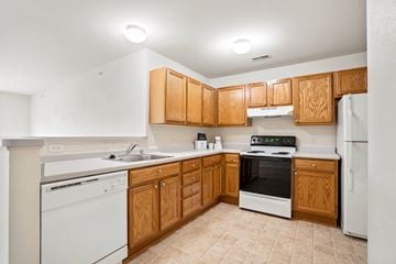Grand Chute apartment for rent - A kitchen with wooden cabinets and white appliances.