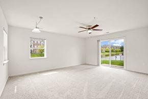 Grand Chute apartment for rent - A spacious room with a ceiling fan and a view of the outdoors through a sliding glass door at Towne Lakes Apartments, Grand Chute