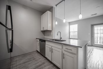 A modern kitchen with a refrigerator, sink, and cabinets
