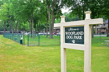 A dog park with a sign that says welcome to woodland dog park