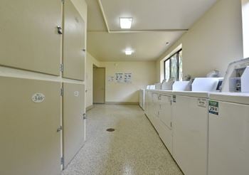 A laundry room with washes and dryers and a door to a door closet