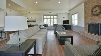 A large living room with couches and a fireplace and a television