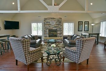 A living room with leather furniture and a stone fireplace
