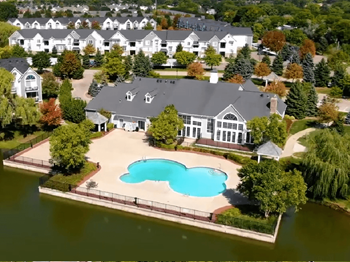 An aerial view of a house with an outdoor swimming pool in front of it