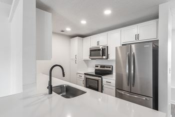 A kitchen with white cabinets and stainless steel appliances