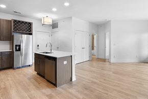 Carmel apartment for rent - a renovated kitchen with a large island and a stainless steel refrigerator in Carmel IN, 46032