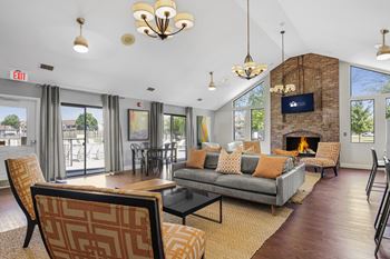 A living room with a grey couch and a fireplace.