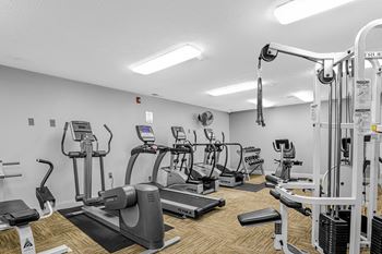 State of the art fitness room includes cardio machines and weights