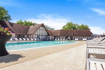 Swimming pool with a white building with a brown roof in the background