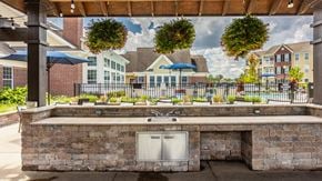 Columbus apartment for rent - a park with a pond in front of an apartment building at The Avenue at Polaris Apartments, Columbus, OH
