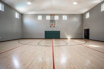 A basketball court with a green wall and a basketball hoop