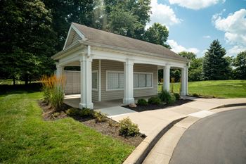 A small white house with a porch and a covered walkway