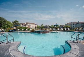Indianapolis apartment for rent - A large outdoor swimming pool with a metal railing around it.
