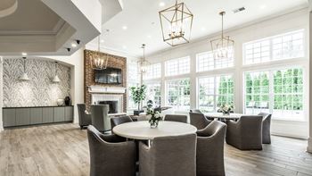Clubhouse lounge with large windows seating and a fireplace 