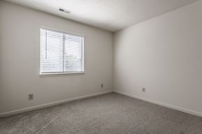 Indianapolis apartment for rent - a bedroom with white walls and carpeted flooring and a window at Bavarian Village Apartments, Indianapolis, Indiana