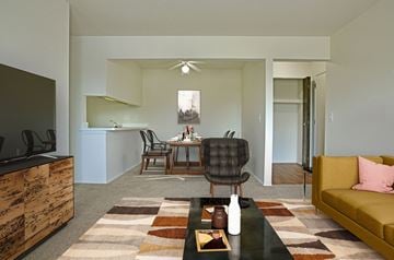 Grand Blanc apartment for rent - a living room with a couch and a coffee table and a dining room and kitchen