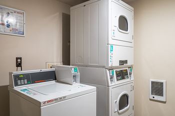 A laundry room with four washing machines and a washer and dryer