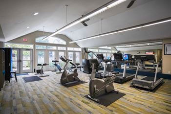A gym with treadmills, elliptical machines, and other exercise equipment