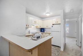 South Bend apartment for rent - a kitchen with white cabinets and a white refrigerator at Hurwich Farms Apartments South Bend, IN