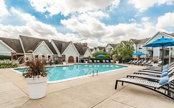 A pool surrounded by lounge chairs and umbrellas