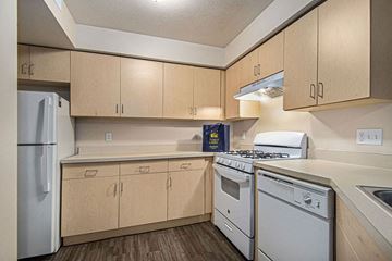 Mishawaka apartment for rent - a kitchen with white appliances and wooden cabinets