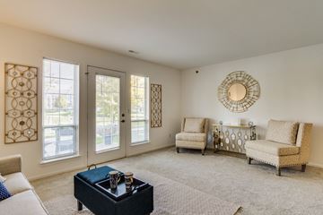 Macomb apartment for rent - A living room with a black coffee table and two chairs.