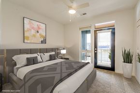Troy apartment for rent - a bedroom with a large bed and a door leading to a balcony  at Uptown Square Apartments, Troy, Michigan